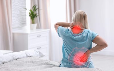 Woman suffering from back pain after sleeping on uncomfortable mattress at home